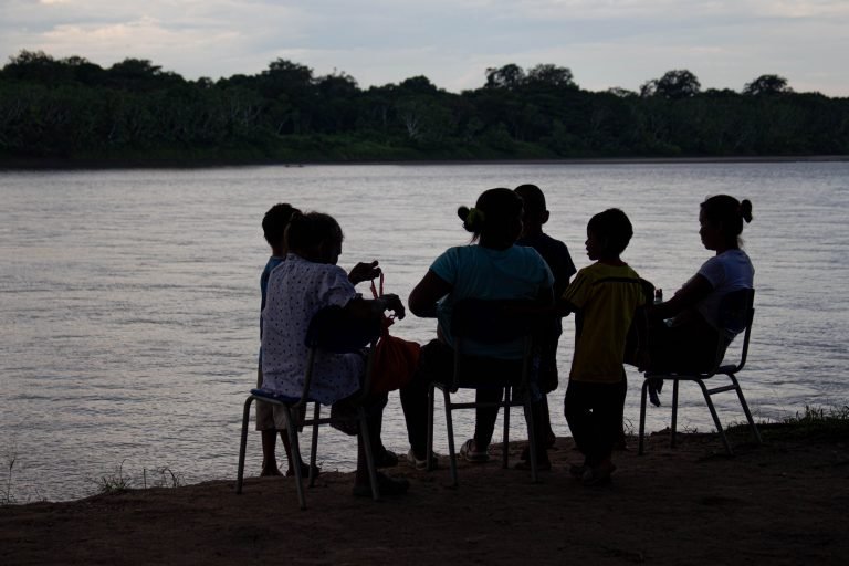 En la foto una familia de la comunidad Jiw, sentados al caer la tarde a orillas del río Guaviare